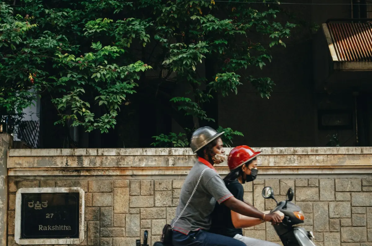 Two people on a scooter, riding home