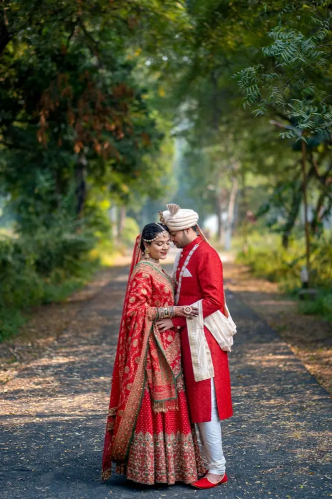 A couple in wedding clothes on a leafy path